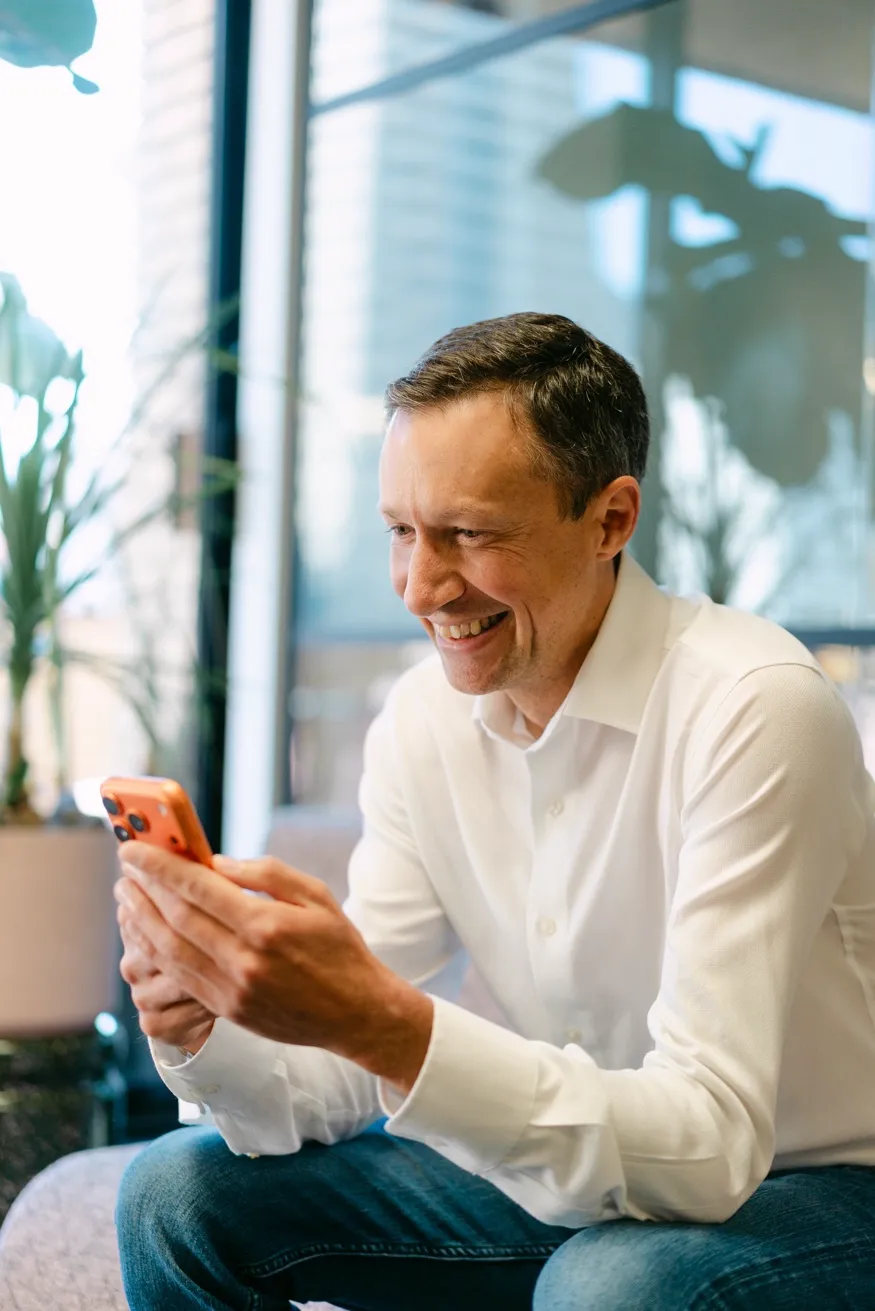 Paul Johnson smiling, looking at phone
